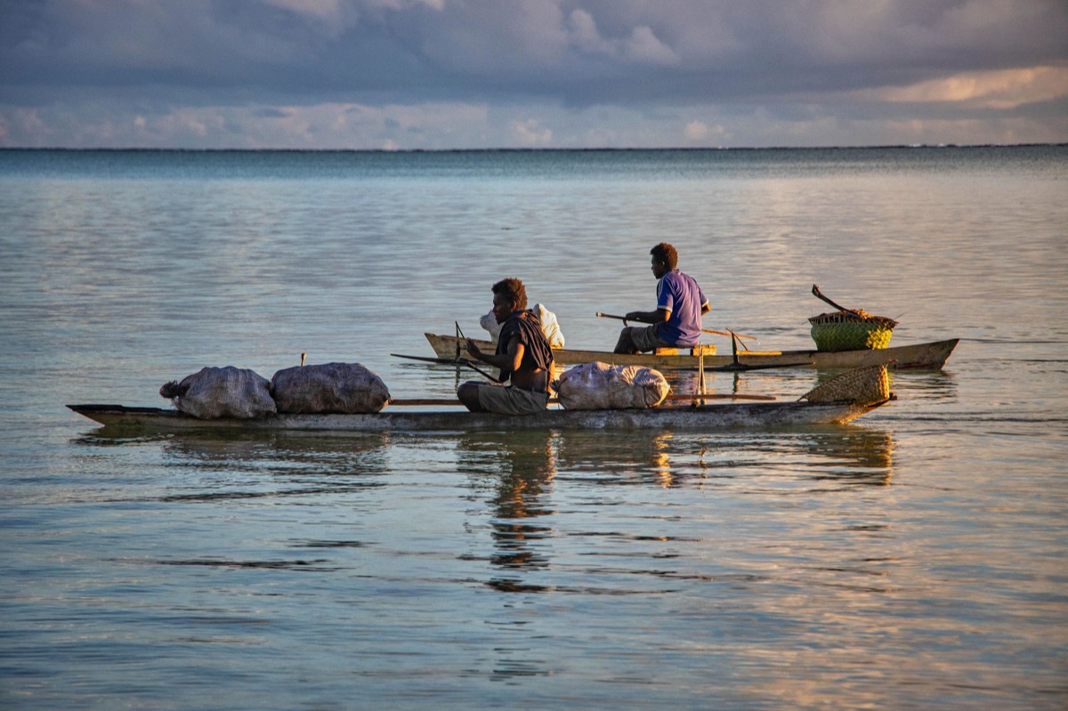 Tahitian island sunset with traditional canoe