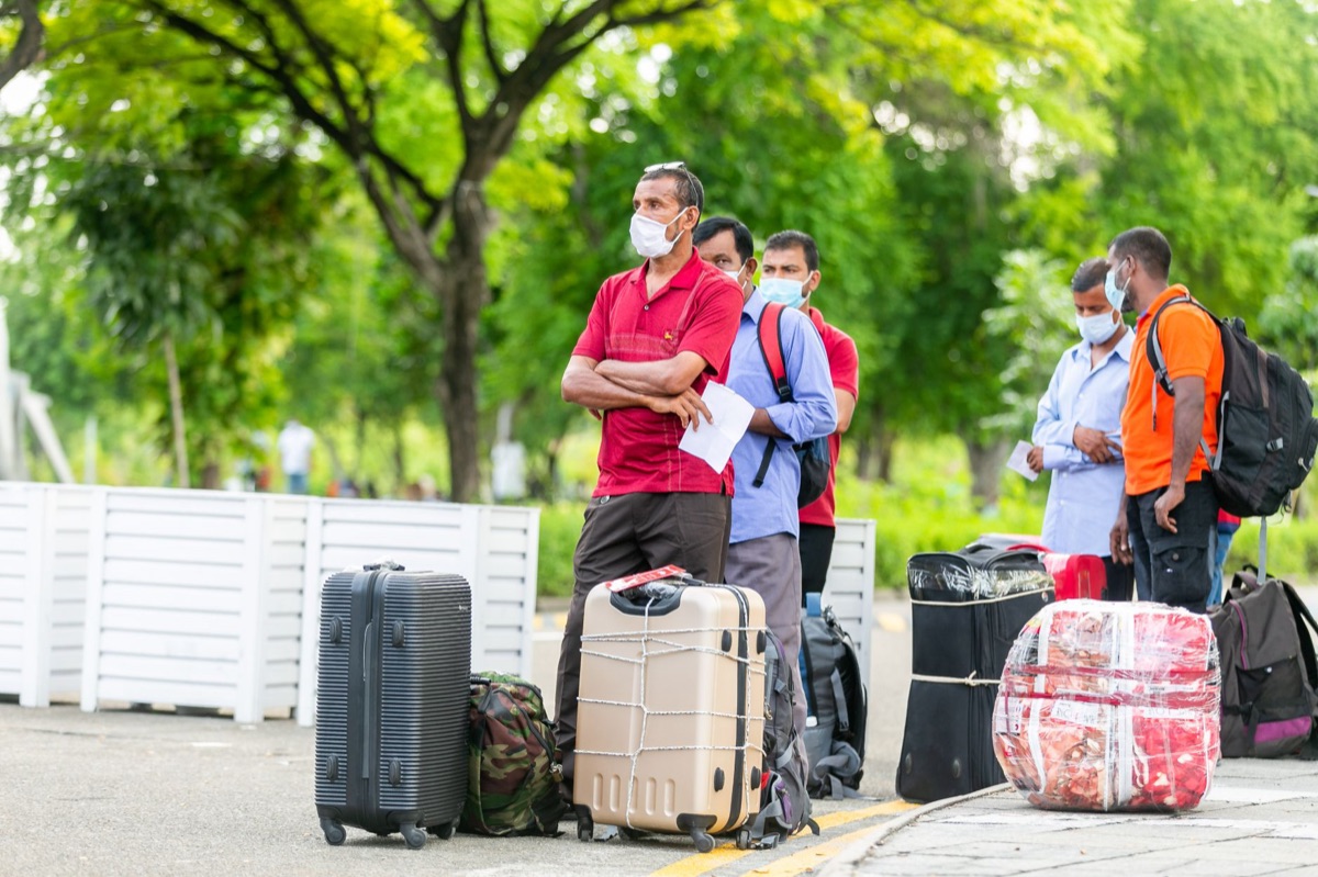 Un voyageur en Tahiti tient un valise