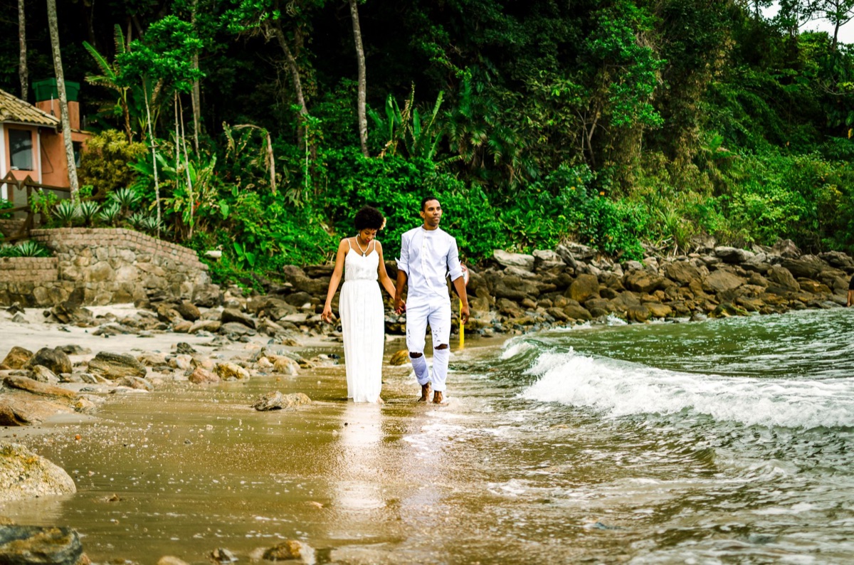 couple walking on white sandy beach