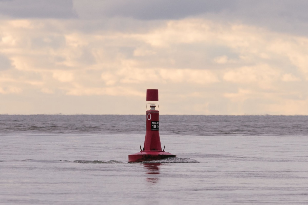 overlapping waves with red safety buoy